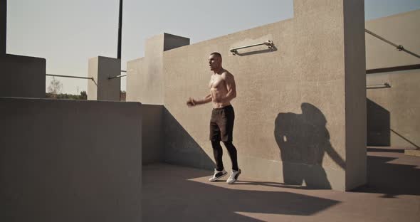 Sportsman Doing Jumping Jacks on Sports Ground alt