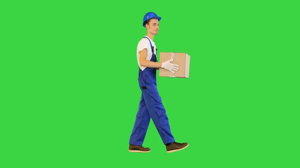 Man Worker Holding a Box and Walking on a Green Screen Chroma Key alt