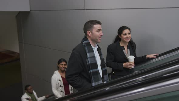 Businesspeople on escalator talking