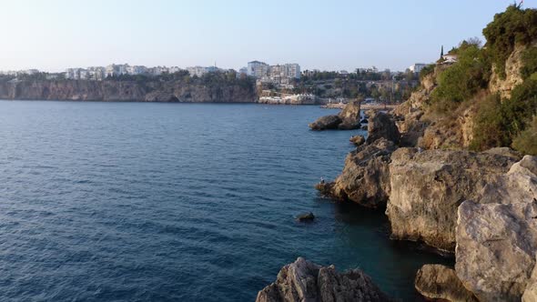 Top View of Rocky Cliffs Over Tuquoise Sea Water alt
