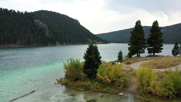 Rising aerial view over Cliff Lake viewing campsite with camper alt