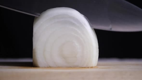 The chef uses a kitchen knife to cut the onions alt