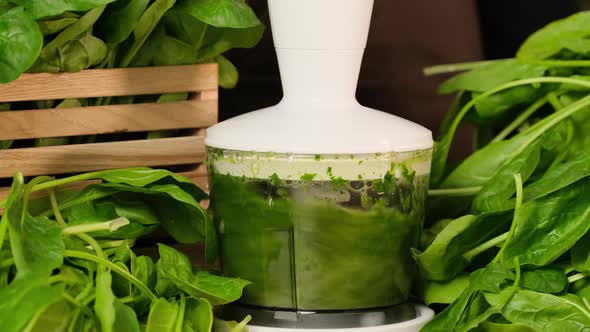 Detox green spinach smoothie blended in blender slow motion. Process of making smoothies in blender