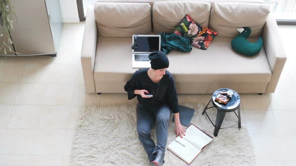 adult woman indoor at home working using smart phone sitting on the floor