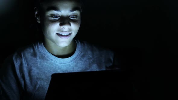 Beautiful Woman Using Digital Tablet in a Dark Room