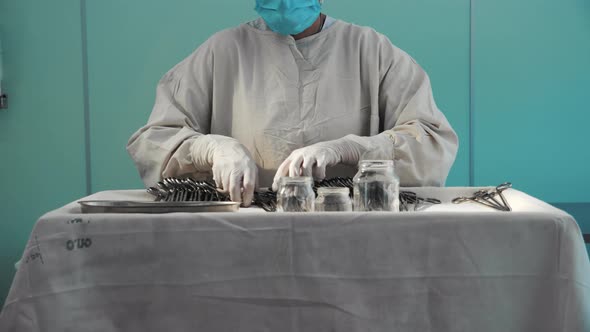 Nurse Putting Surgical Instruments on Table Preparing Tools for Operation alt