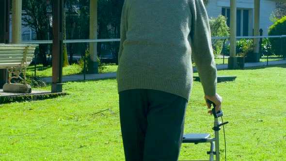 Elderly Man Using His Walker Along the Hospital Rehab Facility Garden alt