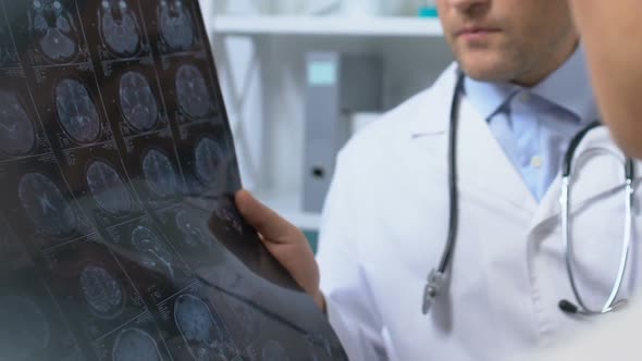 Two Doctors Looking at X-Ray Results, Discussing Patient Symptoms and Diagnosis