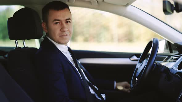 Portrait of Businessman Sitting at the Wheel of a Car