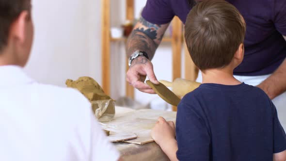 Teacher is Learning Little Boy How to Sculpt From Clay