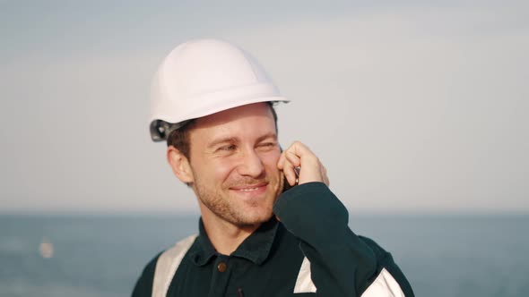 Young Happy Marine Deck Officer Talking with Family or Friends on Mobile Phone Amd Smiling alt