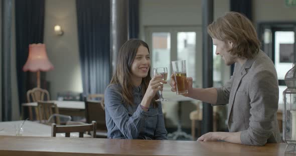 Man and woman enjoying drink while sitting in pub