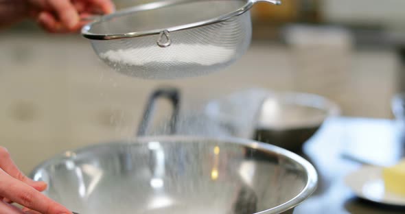 Man using sieve in kitchen at home 4k