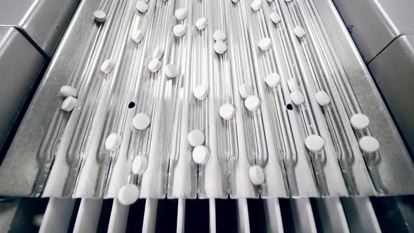 Top View of a Metal Conveyor with Pills on It alt