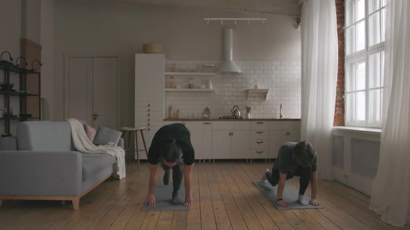 Man and Woman Practicing Yoga at home