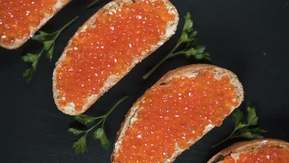 Sandwiches with Red Caviar on Dark Stone Background