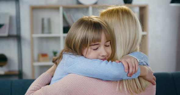 Woman Which Posing with Her Back on Camera During Huggs with Her Daughter at Home alt