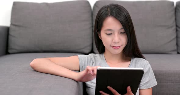 Woman look at tablet computer at home alt