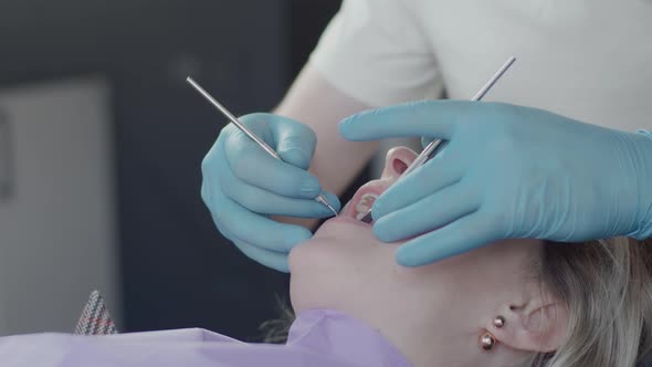 Dentist in protective mask and medical gloves, serve the patient at the dental clinic alt