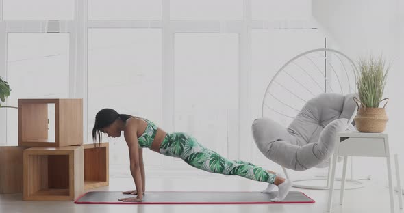 Slim black woman standing in plank position