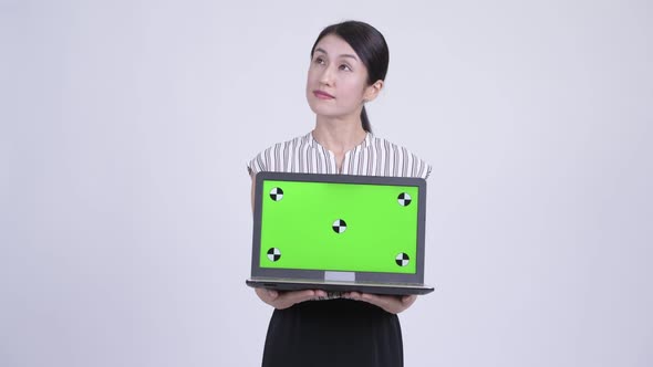 Happy Beautiful Asian Businesswoman Thinking While Showing Laptop alt