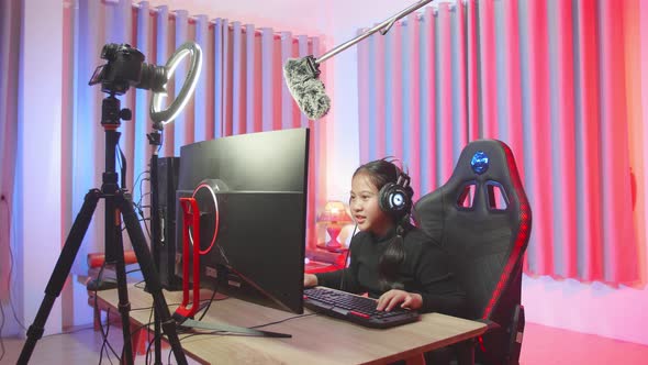 Young Streamer Girl With Headphones Plays Video Game On A Computer alt
