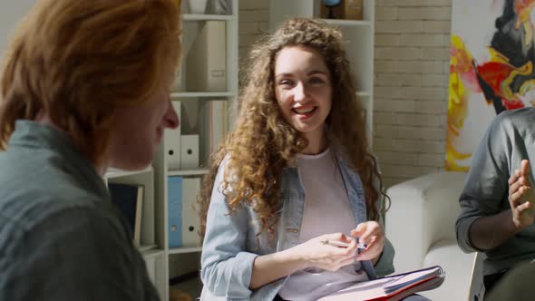Beautiful Young Woman Talking to Colleagues alt