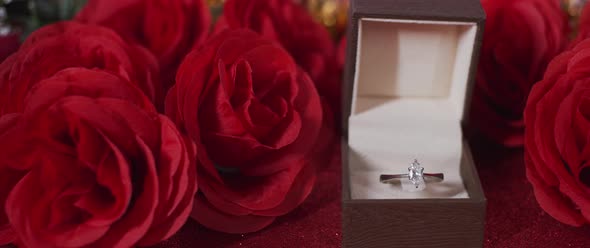 Close up diamond ring and silk red roses