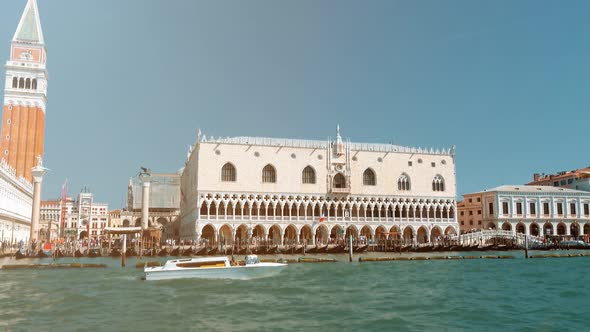 Gondoliers row in their gondola in the canal grande near the bridge of Rialto