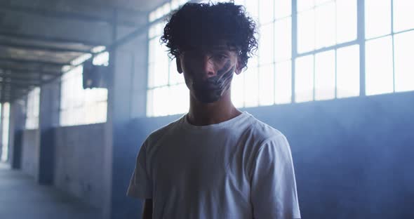 Portrait of african american man with hand mark on their mouth standing in empty parking garage alt
