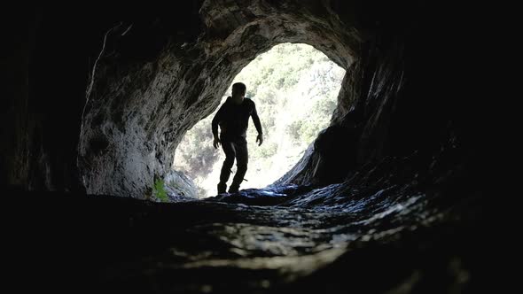 Young explorer in black sportswear in a cave with climbing equipment ready for action alt