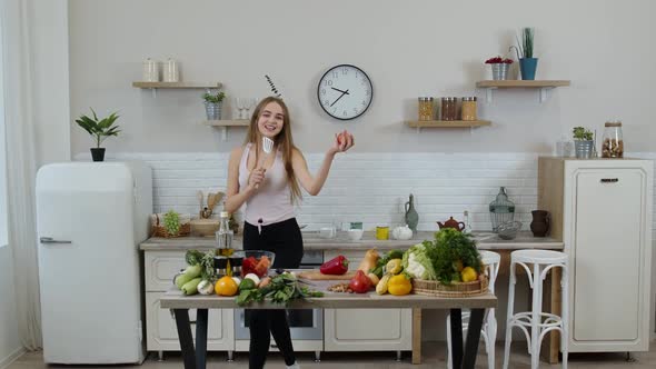 Happy Vegan Girl with Slim Waist Dancing, Singing in Kitchen. Raw Vegetable Nutrition Diet Concept alt