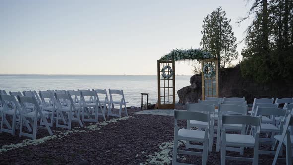 Cinematic shot of a wedding ceremony site located on the shoreline alt