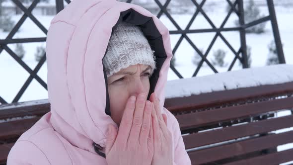 Woman on bench in snowy storm. alt