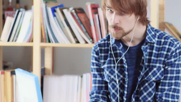Modern Young Man with Headphones Listening Music, Singing