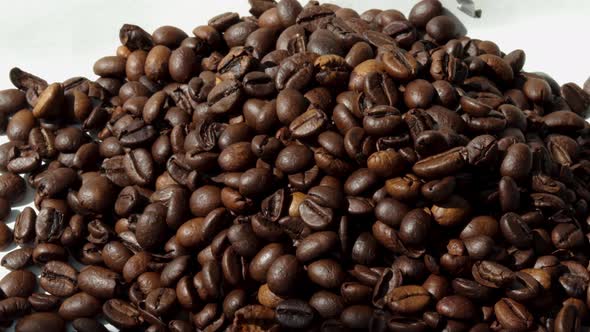 freshly roasted coffee beans falling from pack on table,flat surface,pouring from up down.sunny rays alt