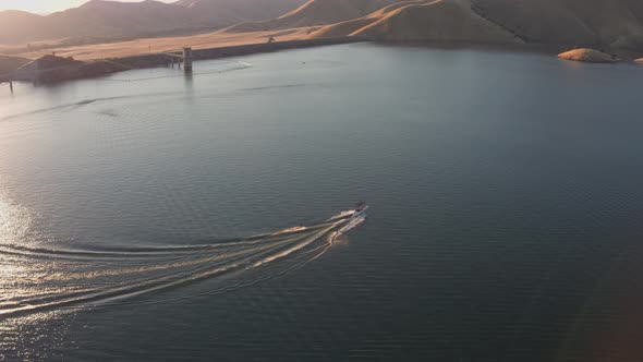 Aerial Drone Tracking Shot of a Boat with Waterskiers on.a Mountain Lake (Lake Kaweah, Visalia, CA)