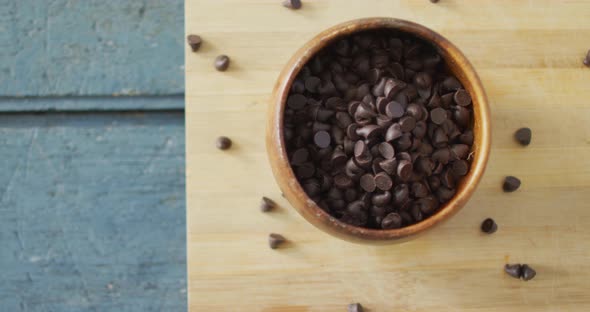 Video of close up of bowl with organic chocolate chip on wooden background alt