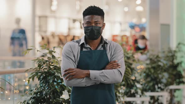 Confident Restaurant Worker in Medical Mask Standing Indoors Barman Seller Waiter in Apron Turns to alt