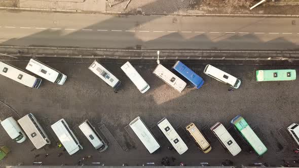 Aerial footage of many buses moving on a busy city street. alt