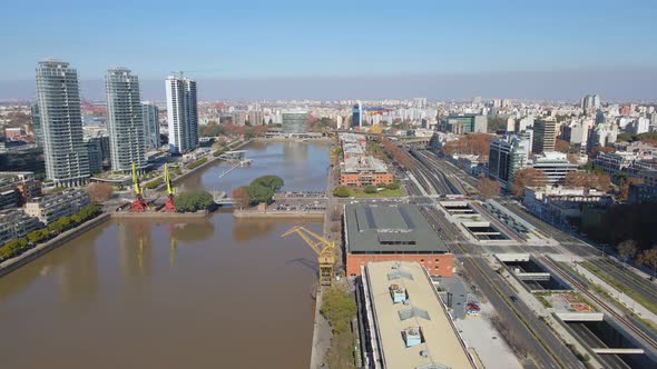 Aerial establishing shot of Puerto Madero's waterway with some buildings at sides alt