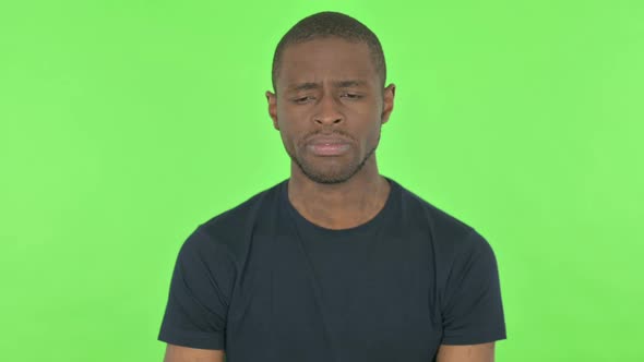 Sad Young African Man on Green Background alt
