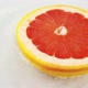Rotating segments of ripe and juicy grapefruit in water on an white background. Slow motion. - VideoHive Item for Sale
