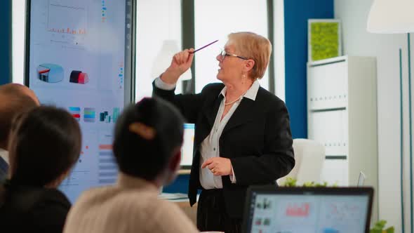 Serious Senior Manager Executive and Diverse Team People Analyzing Digital Project Presentation alt