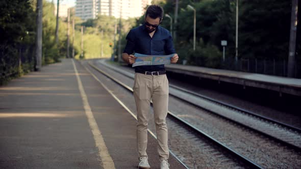 Businessman Tourist Looking On City Paper Map And Exploring City Route. Active Lifestyle On Vacation alt