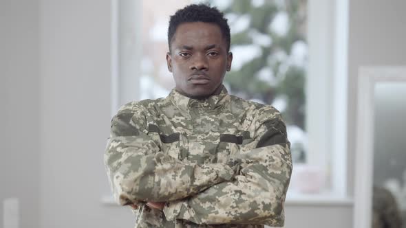 Confident Serious African American Military Man in Camouflage Uniform Crossing Hands Looking at alt
