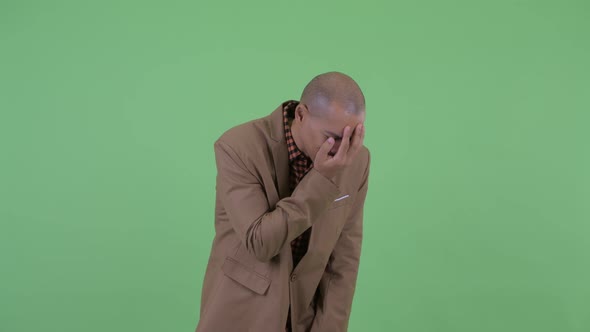 Stressed Bald Multi Ethnic Businessman Looking Sad and Crying alt