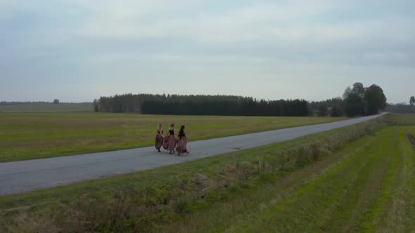 Three Women are Walking on a Road alt