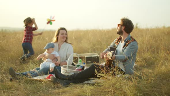 Happy Boy Playing with Parents During Picnic