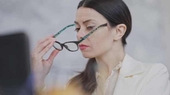 Portrait of Exhausted Young Female Employee or CEO Taking Off Eyeglasses Rubbing Nose and Continues alt